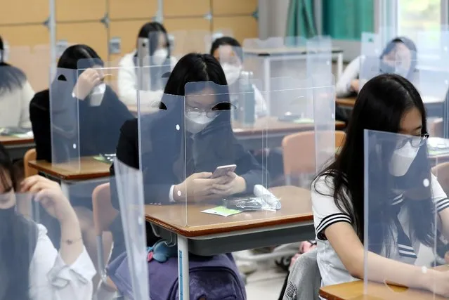 Senior students wait for class to begin with plastic boards placed on their desks at Jeonmin High School in Daejeon, South Korea, Wednesday, May 20, 2020. South Korean students began returning to schools Wednesday as their country prepares for a new normal amid the coronavirus pandemic. (Photo by Kim Jun-beom/Yonhap via AP Photo)