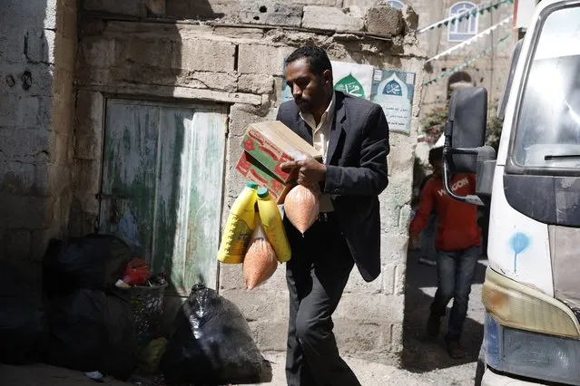 Conflict-affected people get free food rations provided by the Mona relief agency on World Food Day, in Sana'a, Yemen, 16 October 2022. (Photo by Yahya Arhab/EPA/EFE)