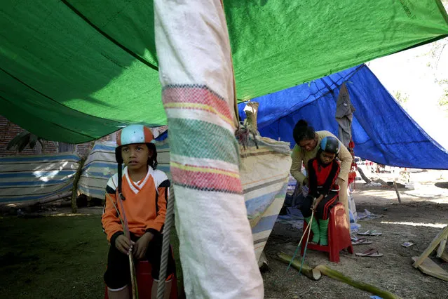 An Indonesian child jockey Sahrul (R), 10, is prepared by his mother as Ardi (L), 9, sits next to them inside a makeshift tent shortly before a traditional horse race marking Indonesia's 70th independence anniversary, in Bima, West Nusa Tenggara province, Indonesia, 08 August 2015. (Photo by Mast Irham/EPA)