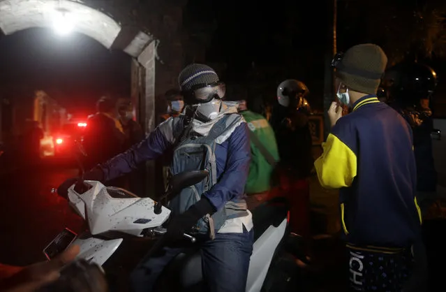 Villagers on their motorbikes after evacuating from their homes which are located near to the crater of Mount Agung, in  Besakih village, Karangasem, Bali, Indonesia, Saturday, November 25, 2017. A volcano on the Indonesian tourist island of Bali erupted for the second time in a week on Saturday, disrupting international flights even as authorities said the island remains safe. (Photo by Firdia Lisnawati/AP Photo)