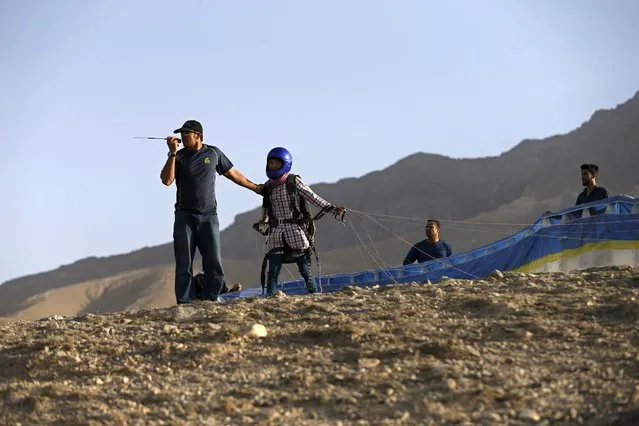 Afghan paraglider Zakia Mohammadi, 21, prepares to take flight in Kabul, Afghanistan September 14, 2015. Mohammadi is one of two women in a group of young Afghans taking to the skies of a capital where military helicopters and surveillance balloons are a far more familiar sight. (Photo by Mohammad Ismail/Reuters)