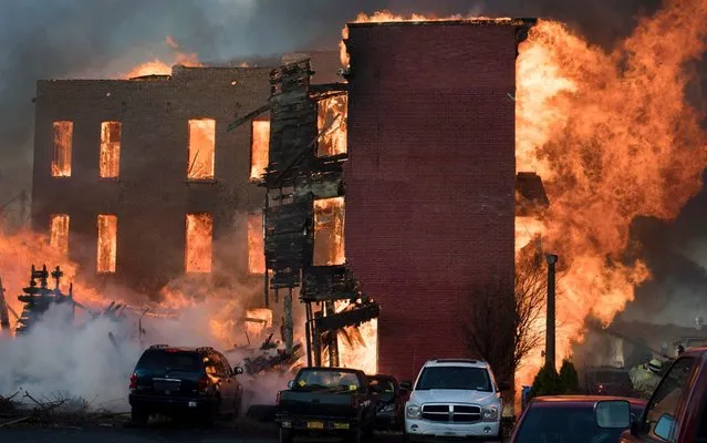 Flames engulfs a building as firefighters from around the region work to control a multi-structure fire on Thursday, November 30, 2017 in Cohoes, N.Y. (Photo by Skip Sickstein/The Albany Times Union via AP Photo)