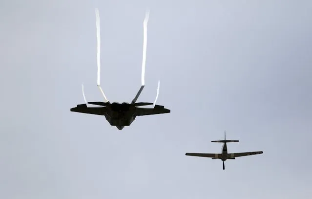 Pilot Kevin Eldridge in a P-51 Mustang and an F-22 Raptor fighter jet piloted by Major John Cummings perform a U.S. Air Force Heritage Flight at the California International Airshow in Salinas, California, September 27, 2015. (Photo by Michael Fiala/Reuters)