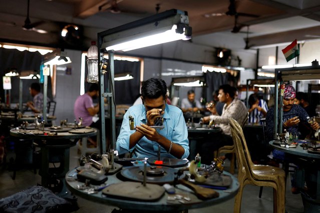 Craftsmen work on diamonds inside a diamond processing unit in Surat, India, on April 3, 2025. (Photo by Anushree Fadnavis/Reuters)