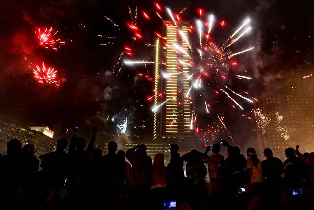 People watch fireworks in Jakarta, Indonesia. (Photo by Dita Alangkara/Associated Press)