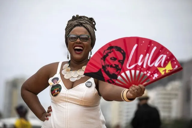A woman holds a fan with the image of Brazil´s former president Luiz Inacio “Lula” da Silva, who is again running for president, during a Black Women´s March, at Copacabana beach in Rio de Janeiro, Brazil, Sunday, July 31, 2022. Brazil's general elections are scheduled for Oct. 2, 2022. (Photo by Bruna Prado/AP Photo)