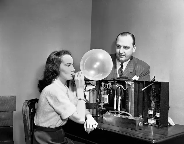 Dorothy Brengel helps W.D. Foden, Chairman of Statler Safety Committee, demonstrate the “Drunkometer”, a breath tests for alcohol, on display at the Greater New York Safety Council, Hotel Statler, March 28, 1950. For the preliminary test, the breath of the suspect is collected in a balloon and passed through a purple fluid (potassium permanganate and sulphuric acid) to see if it changes color. The breath of a non-drinking person will cause no change. If the purple color disappears, the amount of breath required to accomplish this indicates the approximate accumulation of alcohol in the blood. (Photo by Carl Nesensohn/AP Photo)