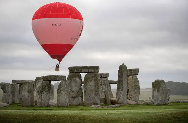 A tethered hot air balloon flies over the ancient neolithic monument of Stonehenge near Amesbury on September 7, 2016 in Wiltshire, England. To mark the 30th anniversary of Stonehenge becoming a World Heritage Site, English Heritage has launched a competition offering members of the public the chance of a hot balloon ride which allows the chance to see a unique view of Stonehenge within in a wider prehistoric landscape but also the see the recent changes to its setting in recent years including the removal of the A344 and the old car park. (Photo by Matt Cardy/Getty Images)