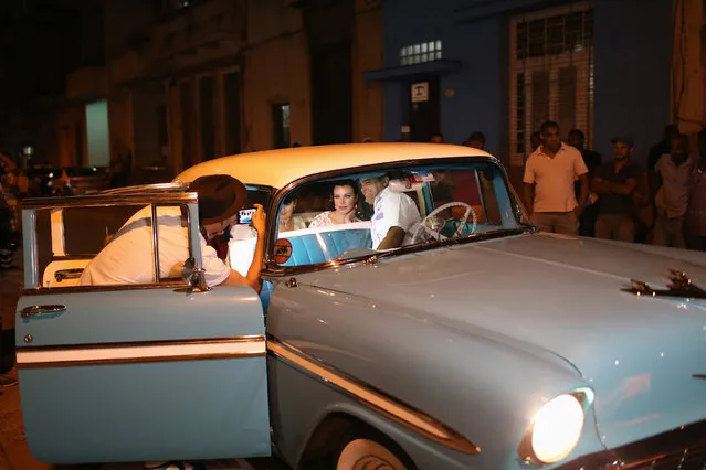Guests take pictures inside a vintage car as they arrive for a dinner with U.S. pop star and singer Madonna (not pictured), in front of a restaurant in downtown Havana, Cuba, August 16, 2016. (Photo by Alexandre Meneghini/Reuters)