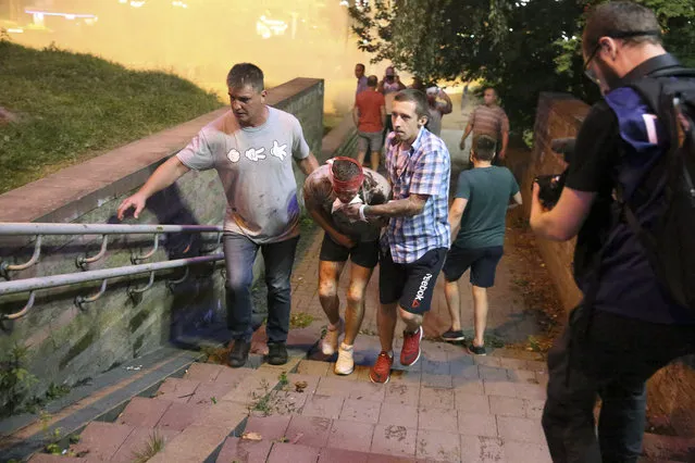 People help a wounded demonstrator during a mass protest following presidential election in Minsk, Belarus, Monday, August 10, 2020. (Photo by AP Photo/Stringer)