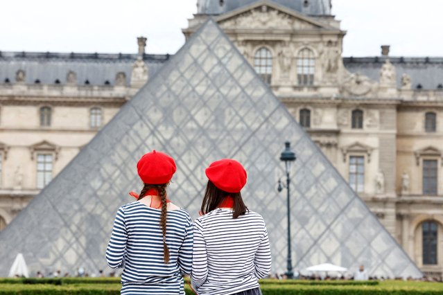 Tourists wearing red berets stand in front of the glass Pyramid of the Louvre museum in Paris, France, on May 5, 2025. (Photo by Abdul Saboor/Reuters)