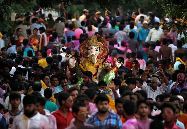 Devotees carrying an idol of the Hindu god Ganesh, the deity of prosperity, make their way to the Yamuna river to immerse the idol on the last day of the ten-day-long Ganesh Chaturthi festival in Delhi, India, September 15, 2016. (Photo by Cathal McNaughton/Reuters)