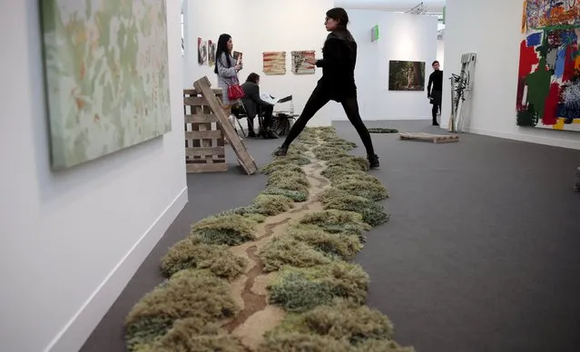 A visitor steps over "Path" by Alexandra Kehayoglou at the Frieze Art Fair in London, Britain October 14, 2015. (Photo by Suzanne Plunkett/Reuters)