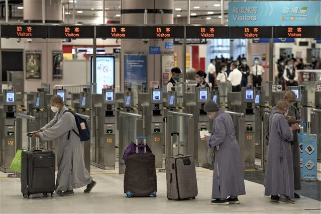 Nuns wearing face masks with their luggage arrive at the immigration counters of the departure hall at Lok Ma Chau station following the reopening of crossing border with mainland China, in Hong Kong, Sunday,  January 8, 2023. (Photo by Bertha Wang/AP Photo)