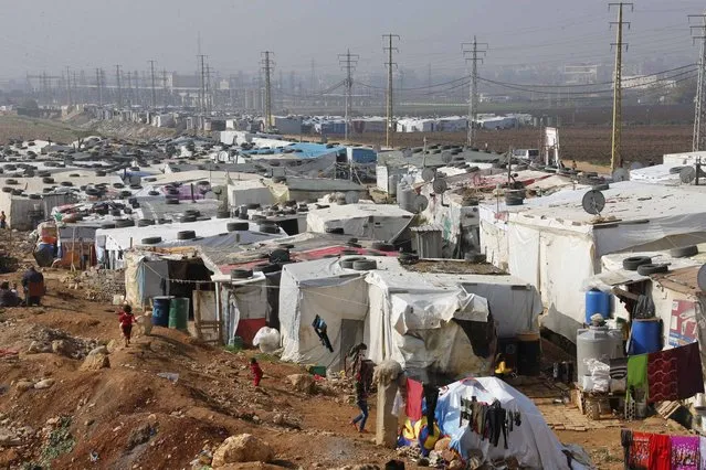 Syrian refugees walk at a refugee camp in Zahle in the Bekaa valley November 18, 2014. (Photo by Mohamed Azakir/Reuters)