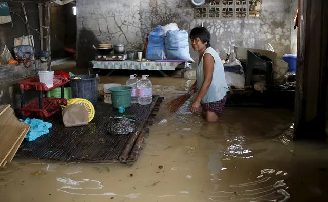 A woman holds a broom inside her flooded house in Cabanatuan, Nueva Ecija in northern Philippines October 20, 2015, after the province was hit by Typhoon Koppu.  A typhoon swept across the northern Philippines killing at least nine people as trees, power lines and walls were toppled and flood waters spread far from riverbeds, but tens of thousands of people were evacuated in time. (Photo by Erik De Castro/Reuters)