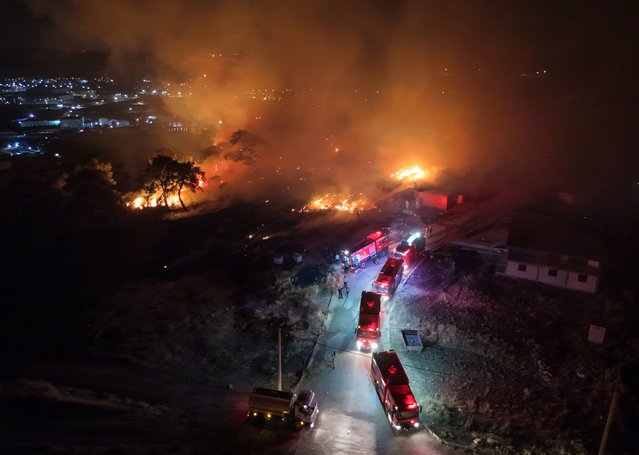 Smoke and flame rise as firefighters continue to extinguish the wildfire that broke out in Aliaga district of Izmir, Turkiye on June 26, 2025. (Photo by Berkan Cetin/Anadolu via Getty Images)