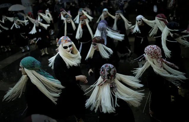 Townswomen dressed as Lamia, with their faces painted white and eyes darkened, sing and dance on Carnival Sunday, in the Basque coastal town of Mundaka, northern Spain, February 11, 2018. The Lamia are Basque mythological creatures whose lower extremities are those of a duck or fish depending on their proximity to the sea, and whose favored activity is combing their long blonde hair with a golden comb. (Photo by Vincent West/Reuters)