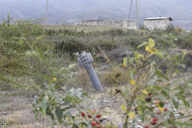 An unexploded projectile of multiple rocket launcher stuck into land near a settlement in self-proclaimed Republic of Nagorno-Karabakh, Azerbaijan, Thursday, October 1, 2020. Two French and two Armenian journalists were injured Thursday in the area of heavy fighting between Armenian and Azerbaijani forces. (Photo by Hayk Baghdasaryan/Photolure via AP Photo)