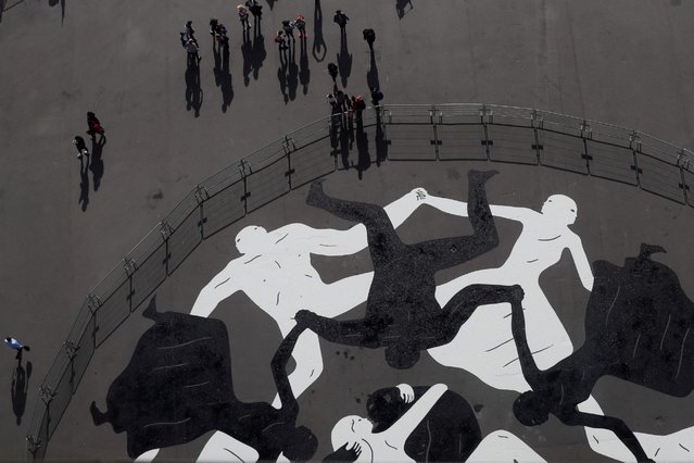 A photo taken on September 28, 2016 in Paris shows “Endless Sleep”, a mural by U.S. artist Cleon Peterson painted under the Eiffel Tower as part of the “Nuit Blanche” festival, that will take place in October. (Photo by Thomas Samson/AFP Photo)