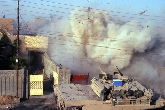 An M1A1 Abrams tank with the 2nd Tank Battalion returns fires into a building after U.S. Marines came under attack in Fallujah, in this December 16, 2004 photo. (Photo by Lance Corporal James J. Vooris/Reuters/USMC/The Atlantic)