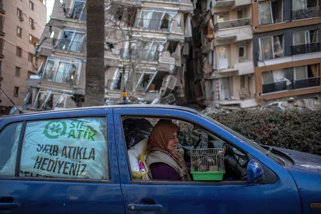 A woman holds a cage with her pet bird as she leaves the city with her husband after a powerful earthquake, in Hatay, Turkey, 16 February 2023. More than 41,000 people have died and thousands more are injured after two major earthquakes struck southern Turkey and northern Syria on 06 February. Authorities fear the death toll will keep climbing as rescuers look for survivors across the region. (Photo by Martin Divisek/EPA)