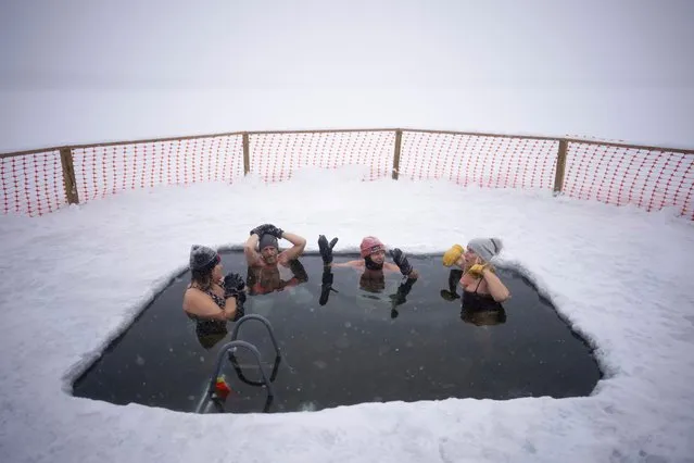 Rachel Banks Kupcho, Matt Nelson, Steve Jewell, and Cindy Murphy, from left, chatted while they soaked in the 33 degree water of Lake Harriet in the snow Wednesday, February 22, 2023, in Minneapolis. (Photo by Jeff Wheeler/Star Tribune via AP Photo)