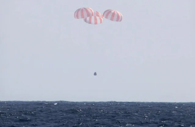 The Dragon capsule uses parachutes to descend to the Pacific Ocean off the coast of Mexico's Baja Peninsula after leaving the ISS, on March 26, 2013. The vehicle brought back more than 1 ton of science experiments and old station equipment. It's the only supply ship capable of two-way delivery. NASA is paying SpaceX more than $1 billion for a dozen resupply missions. (Photo by AP Photo/SpaceX/The Atlantic)