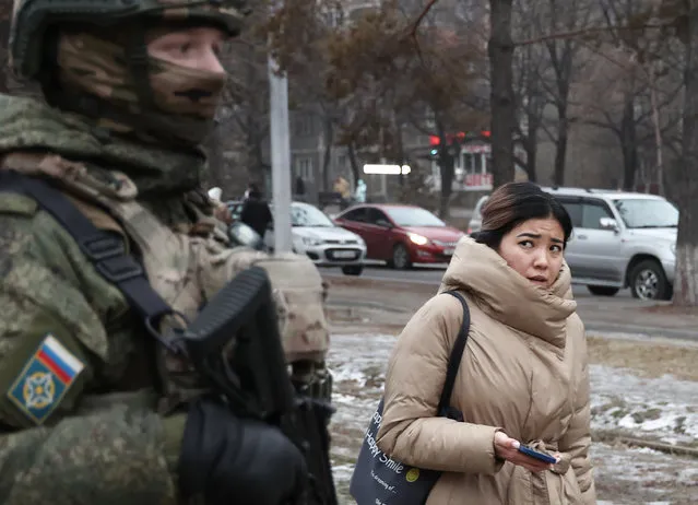 A woman walks past a Russian CSTO peacekeeper in a street in Almaty, Kazakhstan on January 11, 2022. Kazakhstan has been gripped by unrest following protests in the towns of Zhanaozen and Aktau in western Kazakhstan which were sparked by rising fuel prices on 2 January 2022. Kazakhstan's President Tokayev has declared a 2 week state of emergency over mass unrest in the country and asked the Collective Security Treaty Organisation (CSTO) for assistance. On 6 January 2022, according to a decision by the CSTO Collective Security Council, a peacekeeping contingent was sent to Kazakhstan for a limited period of time to stabilise and normalise the situation. (Photo by Valery Sharifulin/TASS)