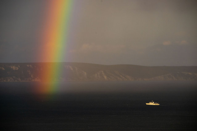 Royal Navy ship HMS Cattistock is seen, as the sun sets with a rainbow, in Weymouth bay, in Dorset, on September 11, 2024 in Portland, United Kingdom. (Photo by Finnbarr Webster/Getty Images)