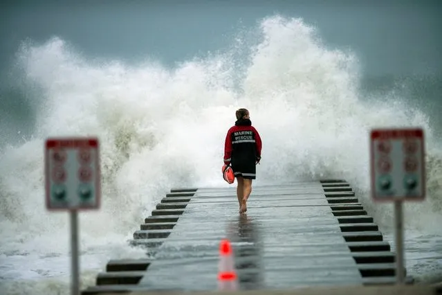 A lifeguard walks to the end of the jetty after closing it down to surfers before the arrival of Tropical Storm Eta in Bradenton Beach, Florida, U.S. on November 11, 2020. (Photo by Steve Nesius/Reuters)