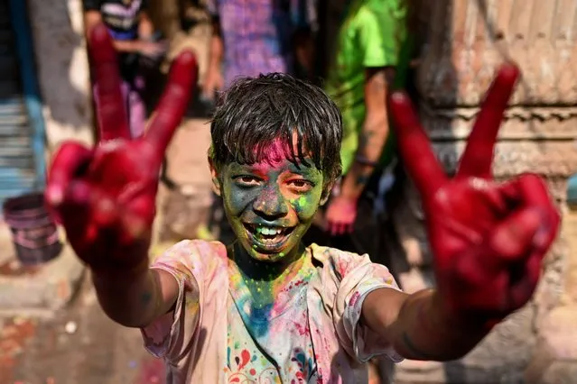 A reveller daubed in “Gulal” or coloured powder poses for a picture during Holi, the festival of colours, in the old quarters of New Delhi on March 8, 2023. (Photo by Sajjad Hussain/AFP Photo)