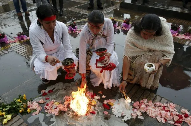 Women light candles during a ceremony for victims and missing people in the rebuilt Justice Palace in Bogota Colombia November 6, 2015. Colombian President Juan Manuel Santos on Friday apologized for military actions during a 1985 assault on Bogota's Palace of Justice by M-19 rebels, in which over 100 people died including nearly half of the country's Supreme Court justices. (Photo by John Vizcaino/Reuters)