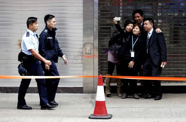 A group of friends take a “selfie” together outside the pro-democracy protest site in the Causeway Bay district of Hong Kong on December 15, 2014. Police arrested protesters as they moved in on December 15 to clear Hong Kong's last remaining pro-democracy site, with just a handful of demonstrators making a final peaceful stand, after the main camp was demolished last week. (Photo by Isaac Lawrence/AFP Photo)
