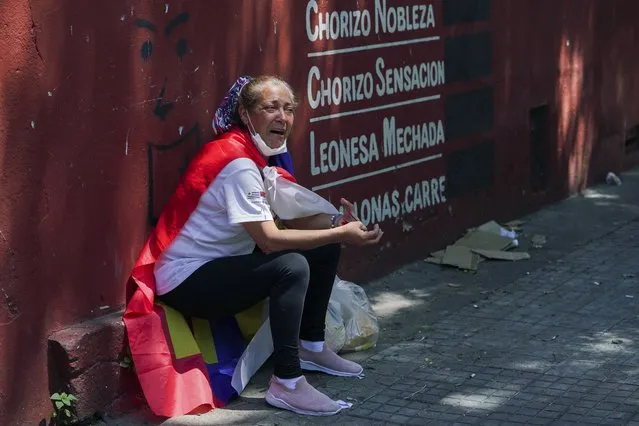 A woman cries after the hearse carrying the casket of former Uruguayan President Tabare Vazquez passed by in Montevideo, Uruguay, Sunday, December 6, 2020. (Photo by Matilde Campodonico/AP Photo)