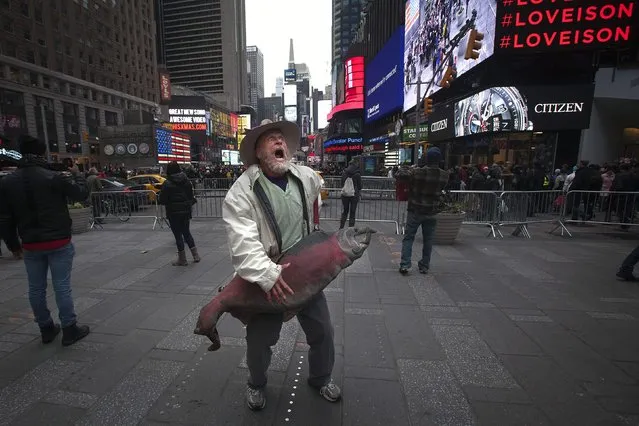 A man sings and dances with a giant fish in Times Square in the Manhattan borough of New York, December 20, 2014. (Photo by Carlo Allegri/Reuters)