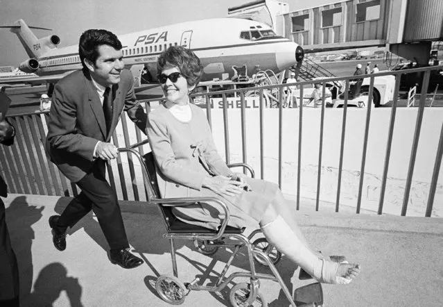 Nancy Reagan, in a knee-length cast, is pushed to waiting plane for return trip to Sacramento, April 3, 1970. The governor's wife broke a bone in her right foot while racing with her 12-year-old son, Skipper, in her Sacramento backyard April 2. Despite the pain and cast, she flew to Los Angeles April 3 to keep an appointment. (Photo by George Brich/AP Photo)