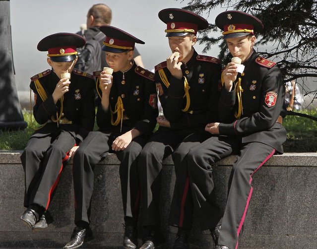 Ukrainian cadets enjoy their ice cream after taking part in a festive ceremony in Kiev, on May 9, 2013. Ukraine commemorates the 68th anniversary of the Soviet Union’s victory over Nazi Germany. (Photo by Gleb Garanich/Reuters)