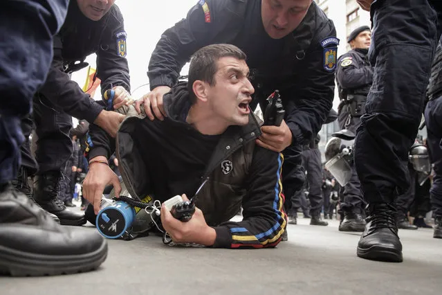 George Simion, leader of a pro-union movement, is detained by Romanian gendarmes following a scuffle between the protesters and the gendarmes during a rally calling for unification of Romania with Moldova, in Bucharest, Romania, October 22, 2016. (Photo by Liviu Florin Albei/Reuters/Inquam Photos)