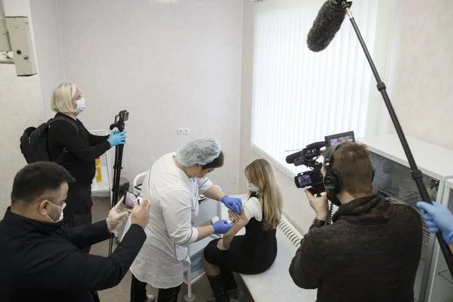 A Russian medical worker administers a shot of Russia's Sputnik V coronavirus vaccine in Moscow on Thursday, December 10, 2020. While excitement and enthusiasm greeted the Western-developed coronavirus vaccine when it was rolled out, the Russian-made serum has received a mixed response, with reports of empty Moscow clinics in the first days of the rollout. (Photo by Pavel Golovkin/AP Photo)