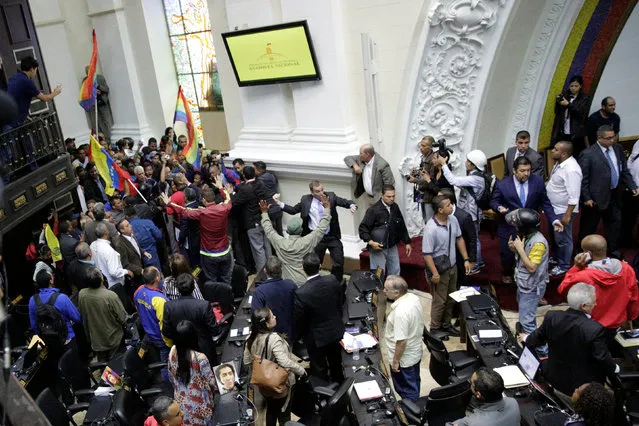 Supporters of Venezuela's President Nicolas Maduro storm into in a session of the National Assembly in Caracas, Venezuela October 23, 2016. (Photo by Marco Bello/Reuters)