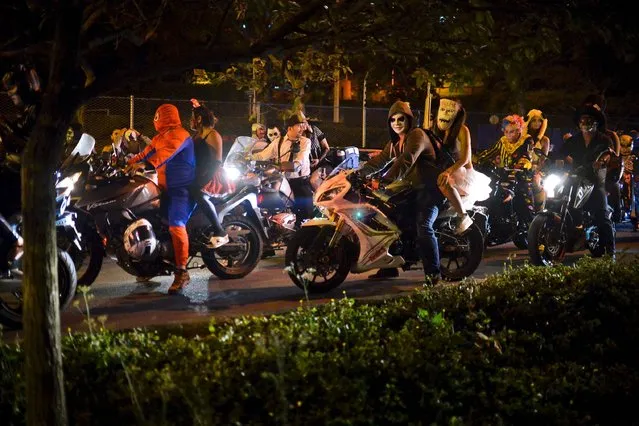Motorcyclists wearing various costumes ride their bikes during a “Moto-Halloween party” along the streets in Cali, Colombia on October 29, 2016. (Photo by Luis Robayo/AFP Photo)