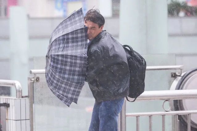A man holds an umbrella against wind brought by Typhoon Haima in Shenzhen, China, October 21, 2016. (Photo by Reuters/Stringer)