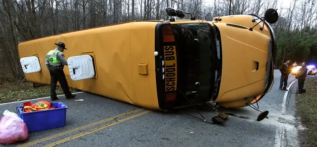 A North Carolina Highway Patrol officer works the scene after a Gaston County school bus overturned in Gastonia, N.C. Wednesday, January 14, 2015. The bus was carrying over forty middle school students when the accident occurred. Fifteen students were transported by ambulance to area hospitals with minor injuries. (Photo by John Clark/AP Photo/The Gaston Gazette)