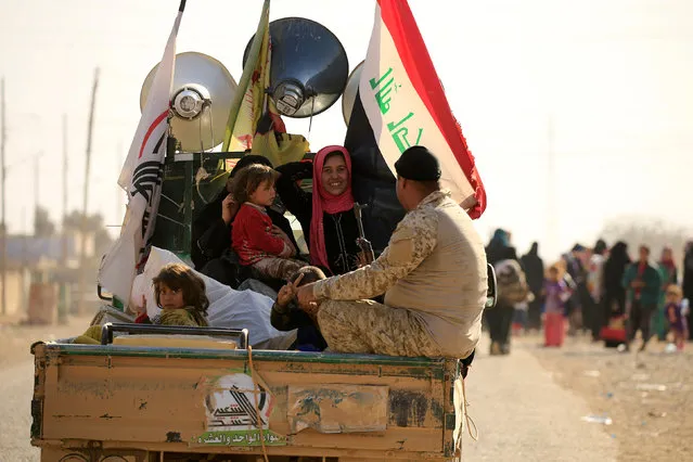 Displaced people who had fled from Hammam al-Alil, south of Mosul, ride a military vehicle to head to safer territory, Iraq November 6, 2016. (Photo by Thaier Al-Sudaini/Reuters)