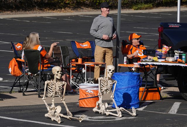 A pair of skeletons serve as Halloween decorations for a tailgate party for Denver Broncos fans before the Broncos host the Carolina Panthers in an NFL football game Sunday, October 27, 2024, in Denver. (Photo by David Zalubowski/AP Photo)