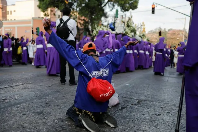 A man kneels down to pray to the passing of the Beatas de Belen procession during Holy Week in Guatemala City, Guatemala on April 12, 2022. (Photo by Luis Echeverria/Reuters)