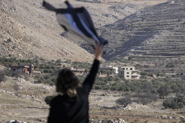 Salma Safadi waves a shirt to her sister Sawsan Safadi, who lives inside the buffer zone near the so-called Alpha Line that separates the Israeli-controlled Golan Heights from Syria, in the town of Majdal Shams, Tuesday, December 17, 2024. (Photo by Matias Delacroix/AP Photo)