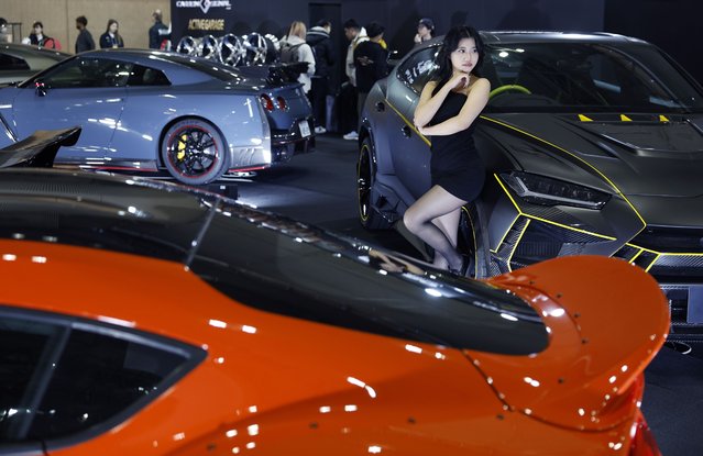 A model poses for visitors during the 2025 Tokyo Auto Salon car show in Chiba, near Tokyo, Japan, 10 January 2025. Tokyo Auto Salon is among one of the top car shows in the world for modified and tuned cars. The annual show will be open to the general public until 12 January 2025. (Photo by Franck Robichon/EPA/EFE)