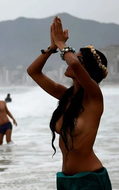 A woman from the topless free movement poses at Iemanja ceremony, the Goddess of the Sea of the Afro-American religion Candomble, during the celebration of Iemanja Day at Arpoador beach in Rio de Janeiro, on 02 february, 2015. (Photo by Christophe Simon/AFP Photo)